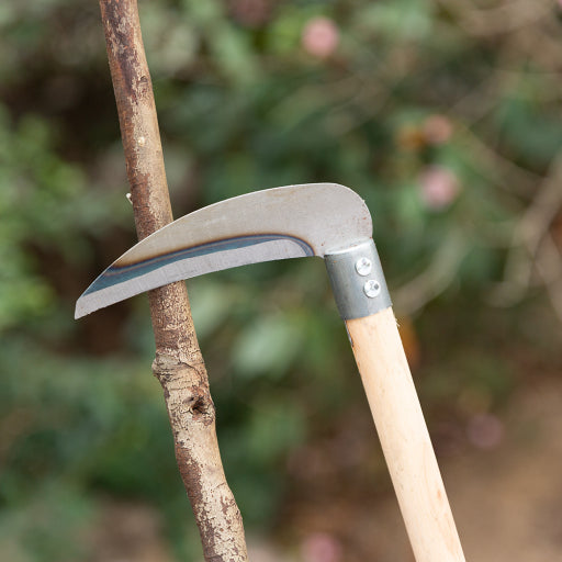 Hoz de jardín con mango de madera.