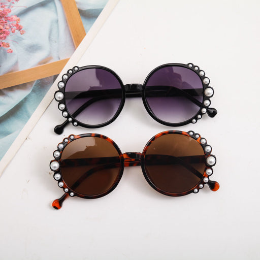 Gafas de sol infantiles con montura redonda y perlas.
