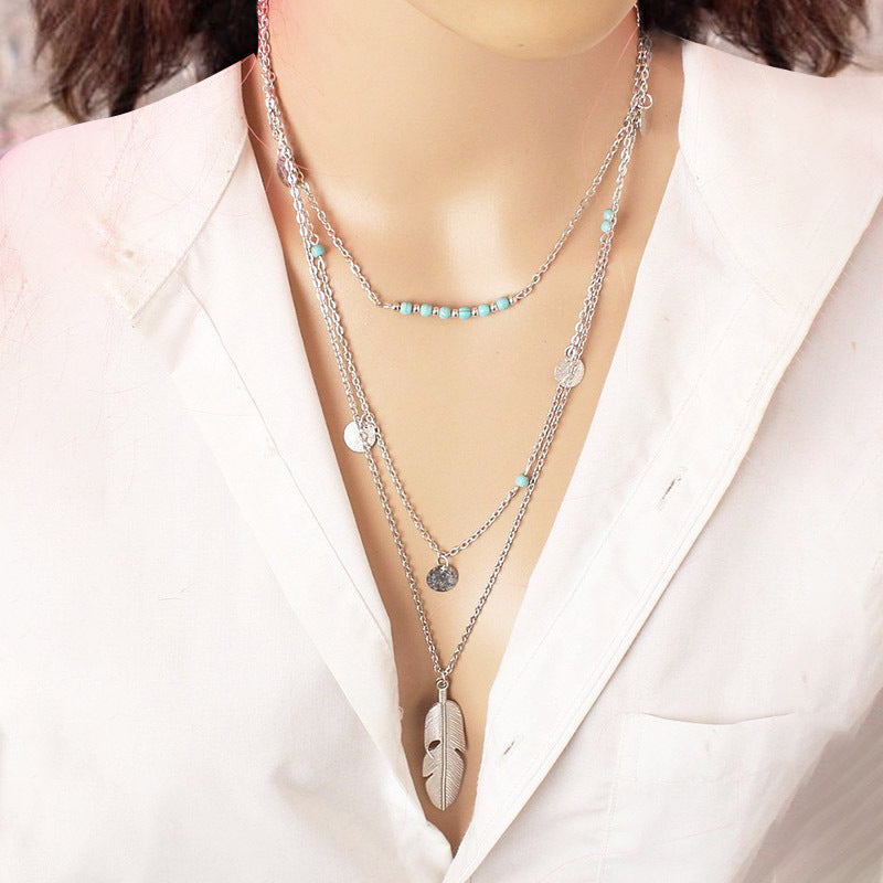 Collar multicapa con pluma