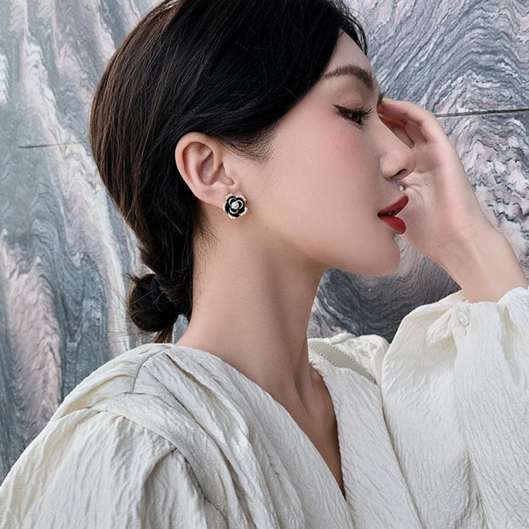 Juego de aretes con forma de flor negro y perla incrustada