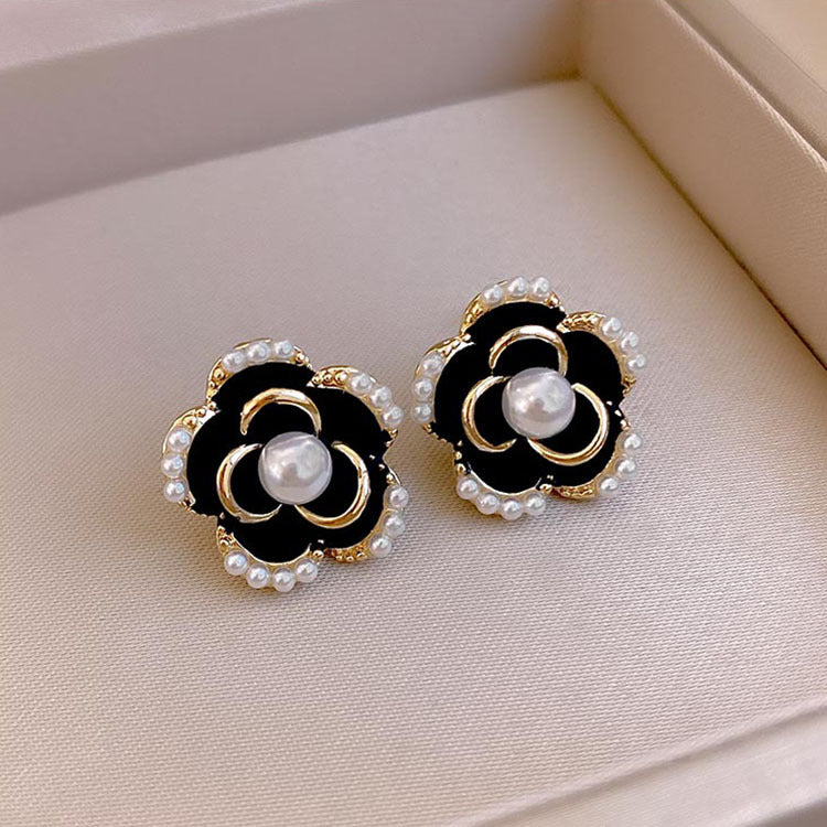 Juego de aretes con forma de flor negro y perla incrustada