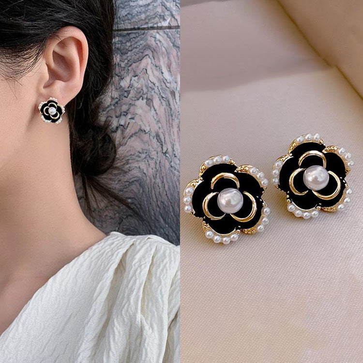 Juego de aretes con forma de flor negro y perla incrustada